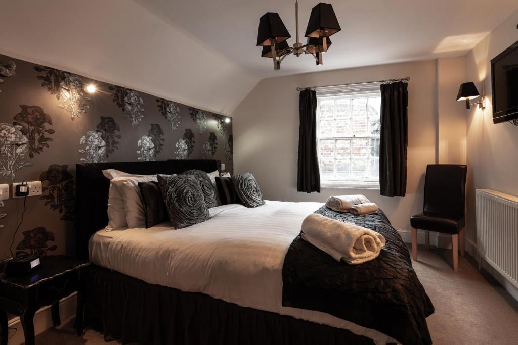 A modern Union Inn bedroom with a black bed, white bedding and a patterned accent wall