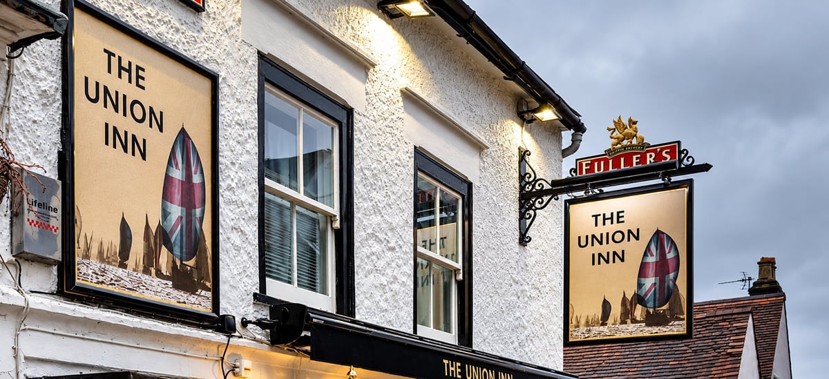 The Union Inn pub exterior with cream and black signage featuring bottle design, windows, and vintage-style storefront on cloudy day