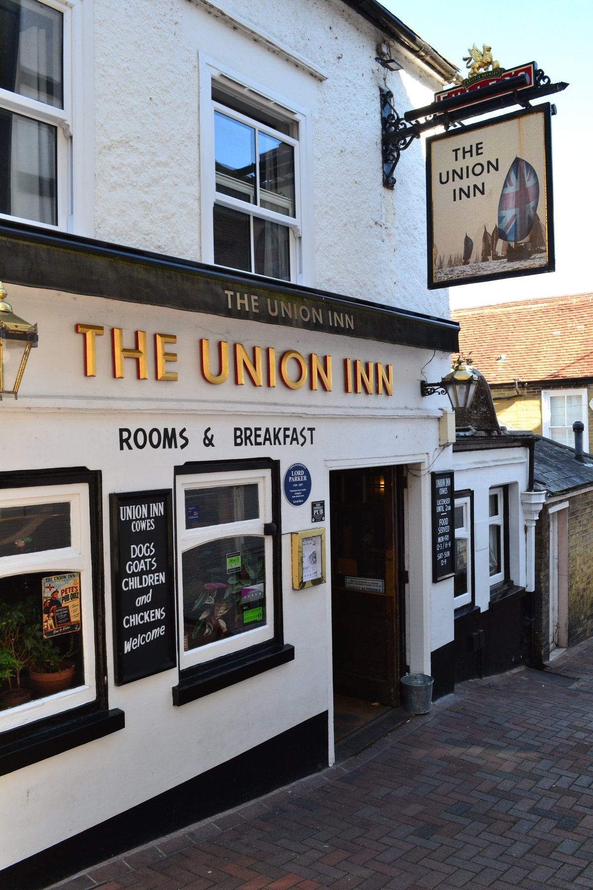 The Union Inn, a white-fronted pub with dark trim offering rooms and breakfast, located on a brick street