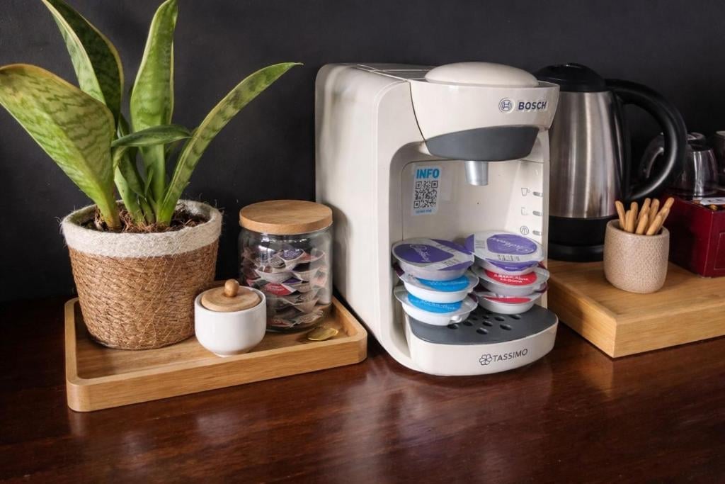 A hospitality tray in a Union Inn room with a Bosch coffee machine, pods and a potted plant